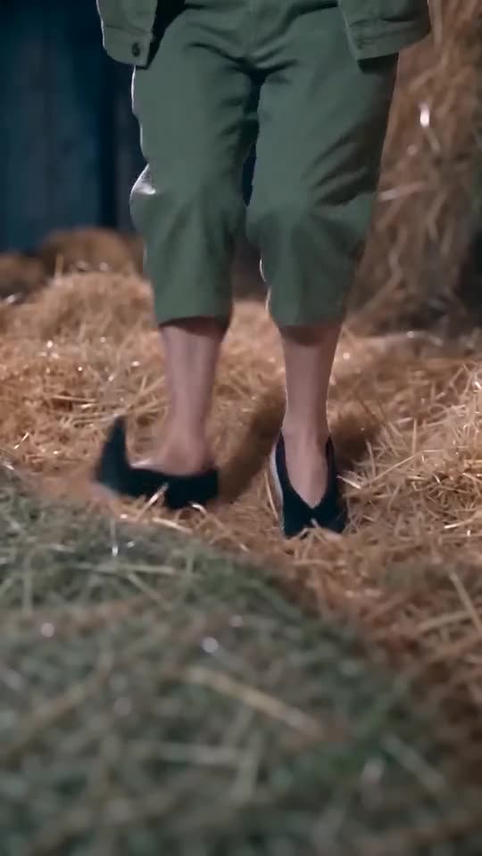 Low frame of the Dancer's sneakers stepping over straw